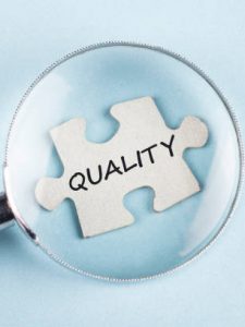 Quality The word Quality on puzzle piece with magnifying glass